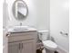 Modern powder room with a white sink, marble countertop, and an oval mirror at 443 Wimbledon Ne Rd, Atlanta, GA 30324