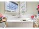 Bright and spacious bathroom featuring a soaking tub, a glass block window, and tile flooring at 374 Cherington Ln, Lawrenceville, GA 30044