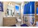 Nautical themed bathroom featuring a vanity with sink, toilet, and a shower with a blue anchor-patterned curtain at 374 Cherington Ln, Lawrenceville, GA 30044