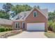 Brick two-story house with a white garage door and stone steps leading to the entrance at 4083 Brookside Manor Dr, Tucker, GA 30084