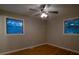 This bedroom features hardwood floors, a ceiling fan, and plenty of natural light from the two windows at 3685 Emily Way, Atlanta, GA 30349