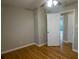 A cozy bedroom with hardwood floors, ceiling fan, and a doorway leading to another room at 3685 Emily Way, Atlanta, GA 30349