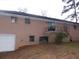 The rear exterior of a brick home with a garage and a small balcony area accessed by a sliding glass door at 3685 Emily Way, Atlanta, GA 30349