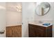 Clean bathroom with dark brown vanity and a round mirror at 261 Quail Run, Roswell, GA 30076