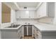 Modern galley kitchen featuring stainless steel dishwasher and white cabinets at 261 Quail Run, Roswell, GA 30076