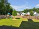 Backyard featuring a wooden fence, a playset with a slide, lush green grass, and mature trees at 1927 Streamlet Xing, Kennesaw, GA 30152