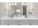 Bathroom featuring double sinks, a wide mirror, and white cabinetry with dark hardware at 1927 Streamlet Xing, Kennesaw, GA 30152