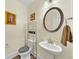 Small half bathroom with pedestal sink, oval mirror, and gray floor at 1927 Streamlet Xing, Kennesaw, GA 30152