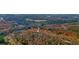 An aerial view of a home nestled in a beautiful wooded landscape with fall foliage at 49 Holly Springs Ne Rd, White, GA 30184