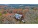 Stunning aerial view of a secluded home nestled amongst vibrant fall foliage and lush trees at 49 Holly Springs Ne Rd, White, GA 30184