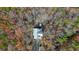 Stunning aerial view of a home nestled in a forest with vibrant fall foliage and a private driveway at 49 Holly Springs Ne Rd, White, GA 30184