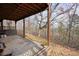 Covered back porch with concrete flooring, wooden supports, and a view of the natural landscape at 49 Holly Springs Ne Rd, White, GA 30184