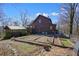 Exterior shot of a cabin with an enclosed wooden structure, garden plots, and wooded backdrop at 49 Holly Springs Ne Rd, White, GA 30184