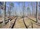 Fenced-in backyard area with sparse ground cover and a seating area with mature trees at 49 Holly Springs Ne Rd, White, GA 30184