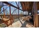 Inviting deck with wooden swing, outdoor furniture, and scenic views of the trees at 49 Holly Springs Ne Rd, White, GA 30184