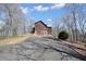 Exterior view of a cabin featuring a long asphalt driveway leading up to a two-car garage at 49 Holly Springs Ne Rd, White, GA 30184