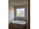 Modern bathroom showcasing a freestanding tub under a frosted window for natural light and privacy at 504 Overlook Rd, Covington, GA 30052