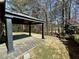 View of covered patio, landscaping and trees in the backyard at 1873 Jameson Cir, Lawrenceville, GA 30043