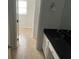 Bathroom showing vanity with black countertop with white cabinets and tiled floor at 229 Smithstone Path, Fayetteville, GA 30214