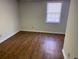 This bedroom features wood-look flooring and a window at 229 Smithstone Path, Fayetteville, GA 30214