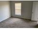 Cozy bedroom with neutral carpet, window with blinds, and a white door at 229 Smithstone Path, Fayetteville, GA 30214