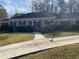 Charming brick home with a well-manicured lawn, mature trees, and a curved walkway leading to the front door at 229 Smithstone Path, Fayetteville, GA 30214