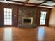 Inviting living room with a stone fireplace, hardwood floors, and natural light from doors to the outside at 229 Smithstone Path, Fayetteville, GA 30214