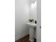 Small powder room with pedestal sink and dark wood floor at 308 Chardonnay Way, Woodstock, GA 30188