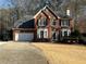 Brick house with a two-car garage and landscaped yard at 1025 Charleston Trce, Roswell, GA 30075