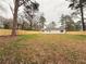 Expansive backyard view of home with new fencing and a grassy area surrounded by mature trees at 413 Cranfill Se Rd, Marietta, GA 30060