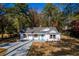 Charming renovated single-story home with a new roof, white siding, a bright blue front door, and a long concrete driveway at 413 Cranfill Se Rd, Marietta, GA 30060