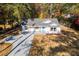 Charming renovated single-story home with a new roof, white siding, a bright blue front door, and a long concrete driveway at 413 Cranfill Se Rd, Marietta, GA 30060