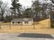 A view of the newly renovated house with wood accents on the windows and the new fence surrounding the property at 413 Cranfill Se Rd, Marietta, GA 30060