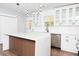 Bright kitchen featuring white cabinets, an island with wood accents, quartz countertops, and modern lighting at 413 Cranfill Se Rd, Marietta, GA 30060