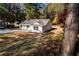 View of the exterior featuring the home's newly seeded yard and freshly poured driveway, surrounded by mature trees at 413 Cranfill Se Rd, Marietta, GA 30060