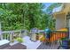 Spacious back deck featuring a grill, a Big Green Egg smoker, and surrounding trees at 27 Danbury Hill # Coweta, Sharpsburg, GA 30277