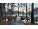 Charming wooden bridge over water, leading to a serene island with trees shrouded in mist at 27 Danbury Hill # Coweta, Sharpsburg, GA 30277