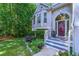 Inviting front entrance showcasing the charming front porch and colorful plants at 27 Danbury Hill # Coweta, Sharpsburg, GA 30277