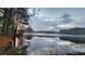 Picturesque lake view with a mirror-like water surface reflecting the cloudy sky and surrounding trees at 27 Danbury Hill # Coweta, Sharpsburg, GA 30277