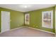 Bedroom with carpet, two windows with blinds, and olive green paint at 4311 Clairesbrook Ln, Acworth, GA 30101