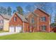 Charming two-story brick home featuring a well-manicured lawn and a two-car garage at 4311 Clairesbrook Ln, Acworth, GA 30101