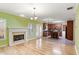 Bright living room with hardwood floors, a white fireplace, and windows overlooking the backyard, next to eat-in kitchen at 4311 Clairesbrook Ln, Acworth, GA 30101