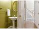 Stylish powder room with pedestal sink, decorative mirror, and easy access to the home's staircase at 4311 Clairesbrook Ln, Acworth, GA 30101