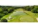 Aerial view of a verdant golf course with mature trees and a pond at 6705 Brookline Ct, Cumming, GA 30040