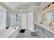 Bathroom featuring double sink vanity with a glass-enclosed shower and tub at 6705 Brookline Ct, Cumming, GA 30040