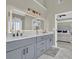 Bathroom featuring a double vanity, quartz countertops and a large, lighted mirror at 6705 Brookline Ct, Cumming, GA 30040