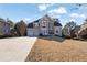 Charming two-story home featuring a manicured front yard, three-car garage, and elegant stone and stucco accents at 6705 Brookline Ct, Cumming, GA 30040