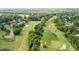 Aerial view of a meticulously maintained golf course with a pond and mature trees at 6705 Brookline Ct, Cumming, GA 30040