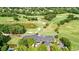 An aerial view of a golf course and country club featuring lush greenery, ponds, and trees at 6705 Brookline Ct, Cumming, GA 30040