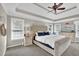 Spacious main bedroom with tray ceiling, fan, and a comfortable king-sized bed at 6705 Brookline Ct, Cumming, GA 30040